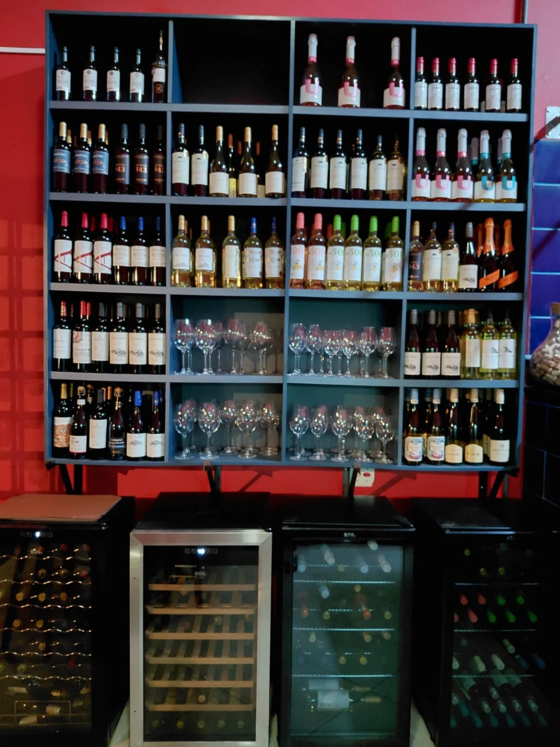 Adega do Empório Europa com rótulos de vinho e taças